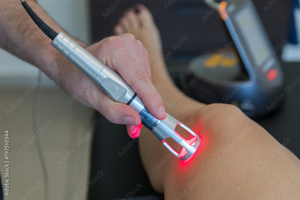 Foto de Laser therapy on a knee used to treat pain. selective focus do
