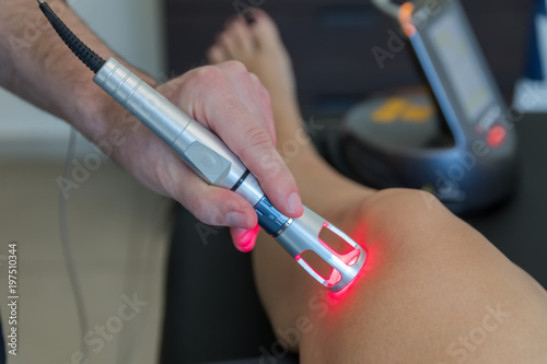 Obraz na płótnie Laser therapy on a knee used to treat pain. selective focus