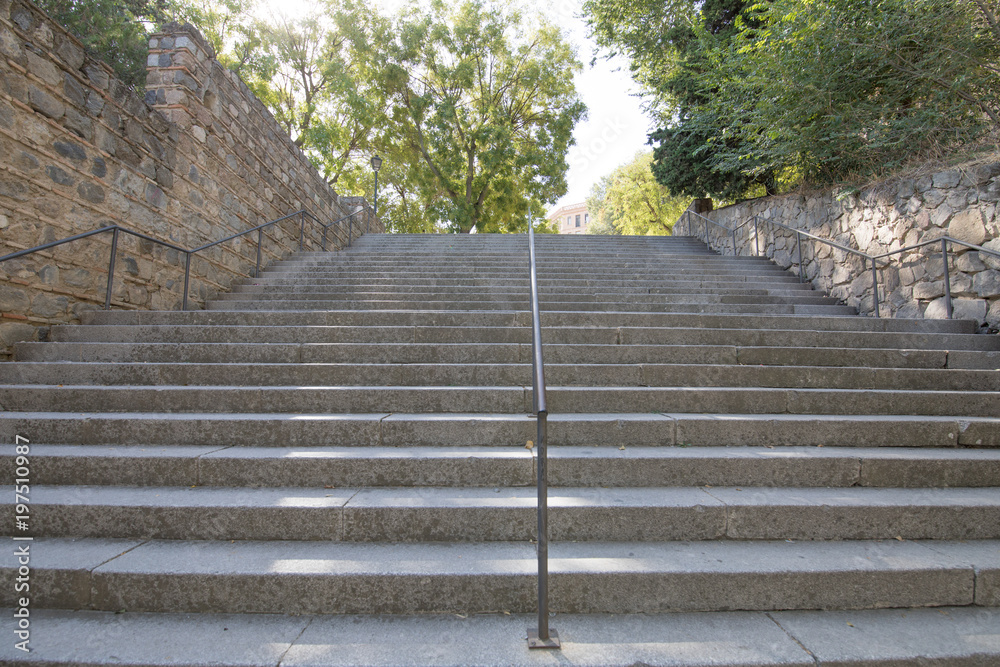 concrete stairs with metal balusters going up in Toledo city, Spain, Europe
concrete stairs with metal balusters going up in Toledo city, Spain, Europe