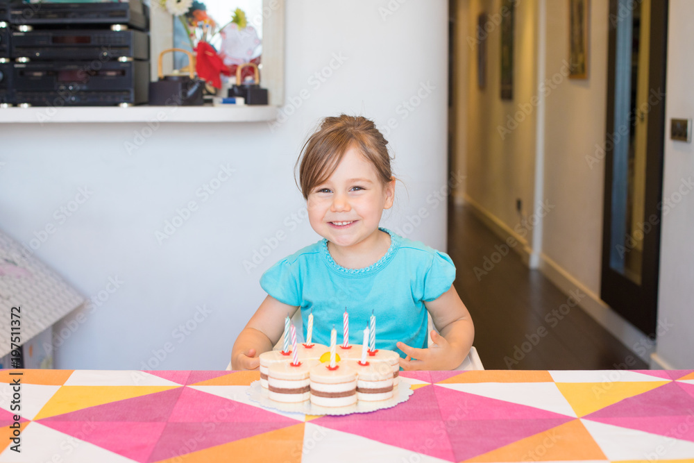 portrait of happy three years old blonde child smiling looking with birthday cake with candles on colorful tablecloth at home
portrait of happy three years old blonde child smiling looking with birthday cake with candles on colorful tablecloth at home