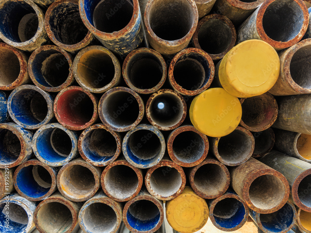 Mental scaffold pipe stack together on scaffold plank wood shelve with blue, green and yellow mark at the tip for build the temporary structure. Mental scaffold pipe stack together on scaffold plank wood shelve with blue, green and yellow mark at the tip for build the temporary structure.