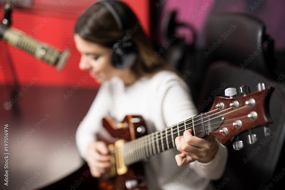 Fototapeta premium Singer playing guitar and singing a song live on radio