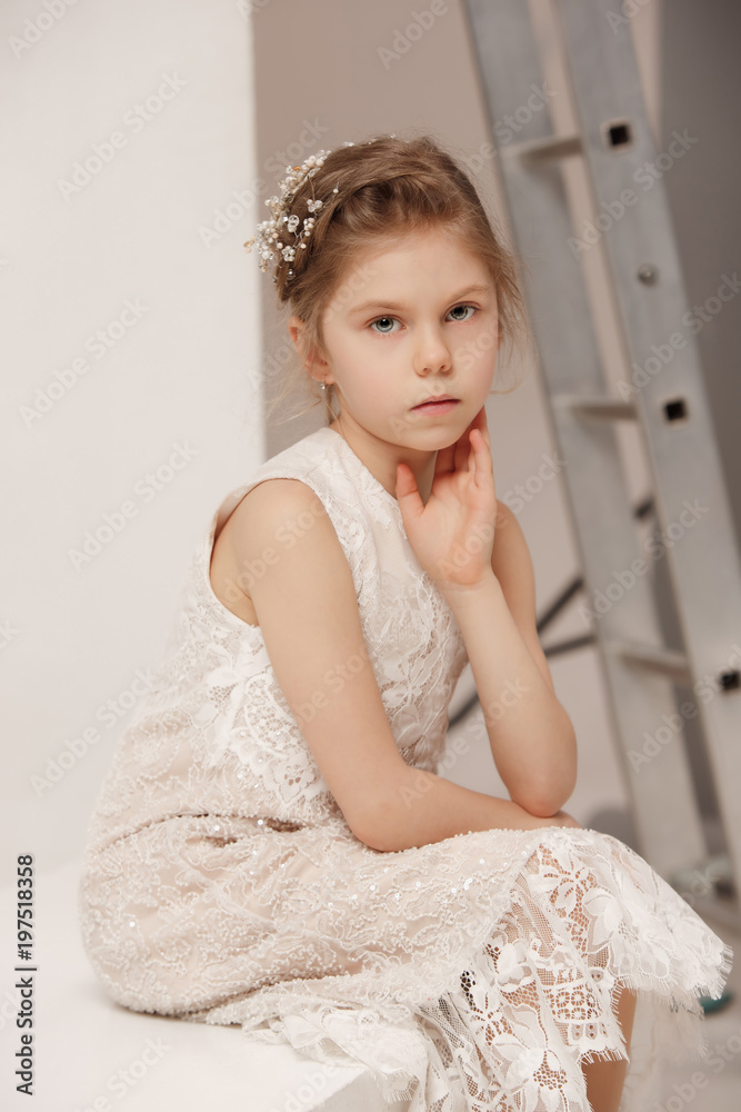 Little pretty girl with flowers dressed in wedding dresses Little pretty girl with flowers dressed in wedding dresses
