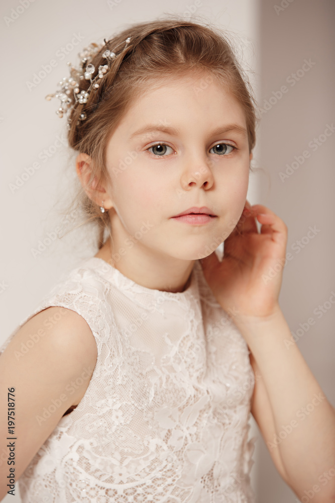 Little pretty girl with flowers dressed in wedding dresses Little pretty girl with flowers dressed in wedding dresses