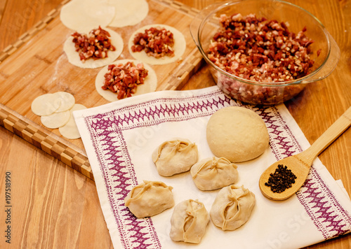 Manti dish. National Uzbek dish with meat and onion. Raw manti on a solid background with flour.