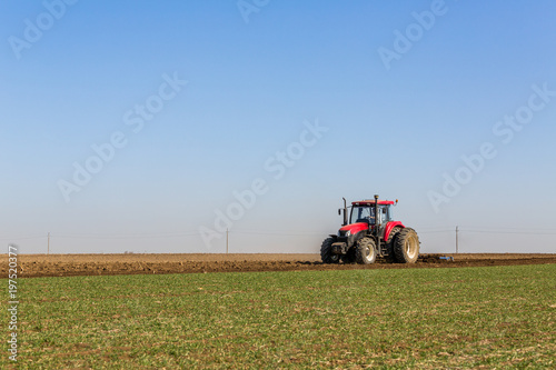 Tractor cultivating field at spring