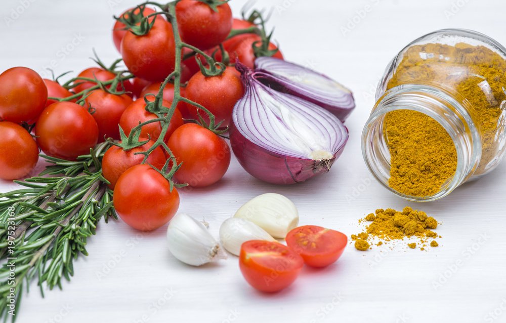 Bunch of tomatoes with garlic, rosemary and curry on white background Bunch of tomatoes with garlic, rosemary and curry on white background