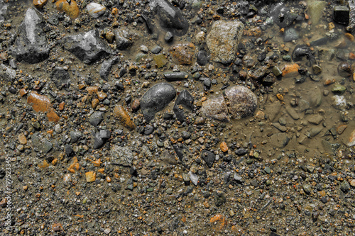 Stone background. Wet ground and stones. Natural background. Stony ground. Puddle. Stony soil. Gravel. Abstract background