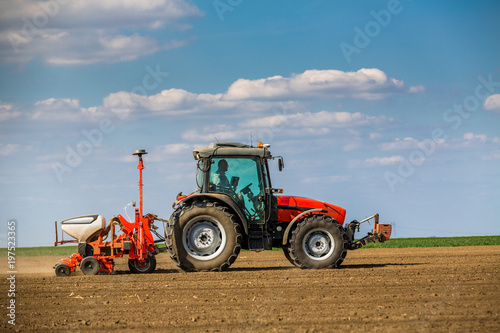 Farmer seeding  sowing crops at field. Sowing is the process of planting seeds in the ground as part of the early spring time agricultural activities.