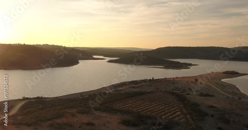 Flying over magical mystic lake sunrise near a misty forest pivot aerial push in shot photo