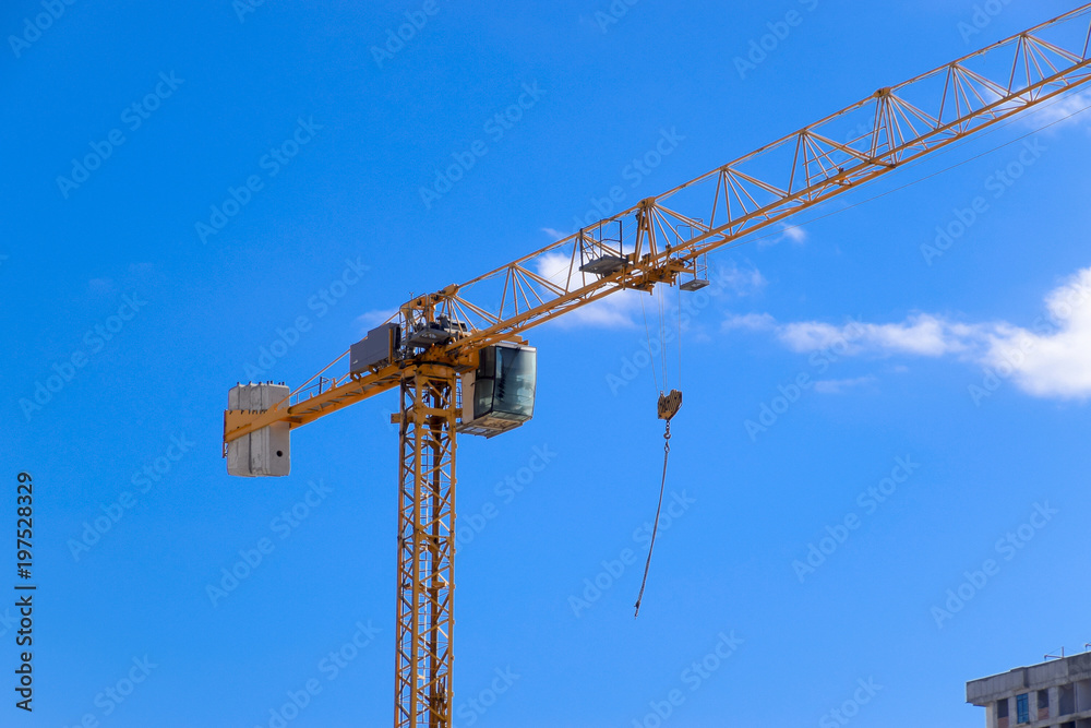 Tower building crane against the blue sky and sun. Construction of new buildings with a crane. Tower crane Tower building crane against the blue sky and sun. Construction of new buildings with a crane. Tower crane