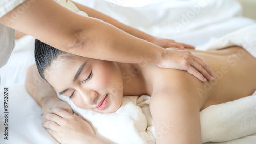 Beautiful and healthy young woman relaxing with back massage in spa salon