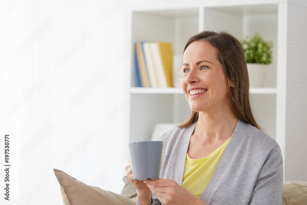 people, drinks and leisure concept - happy middle-aged woman with mug drinking tea or coffee at home people, drinks and leisure concept - happy middle-aged woman with mug drinking tea or coffee at home