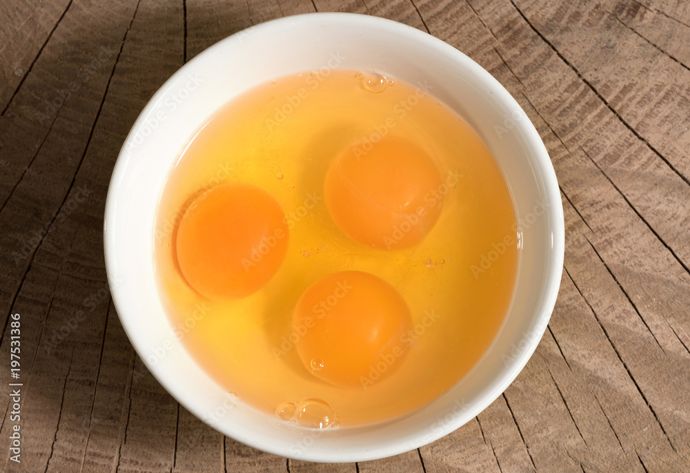 Yolk in a ceramic dish on a wooden background, top view Yolk in a ceramic dish on a wooden background, top view