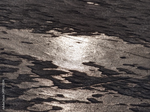 Ocean under transparent ice cover. The sun glare on the flat ice