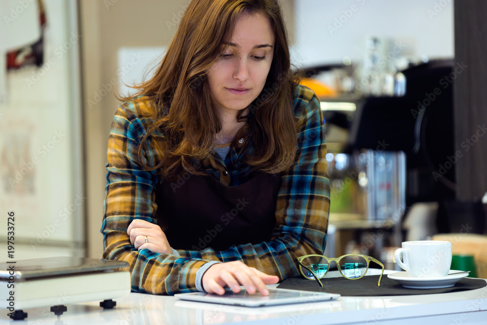Fototapeta premium Beautiful young saleswoman using her digital tablet in organic shop.