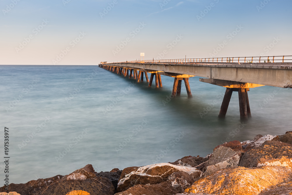  abandoned dock in the mediterranean sea with a cloudless sky