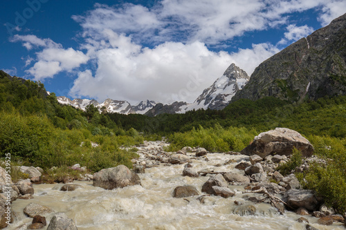 Movement of clouds and water flows in a stormy river in the Caucasus mountains in summer