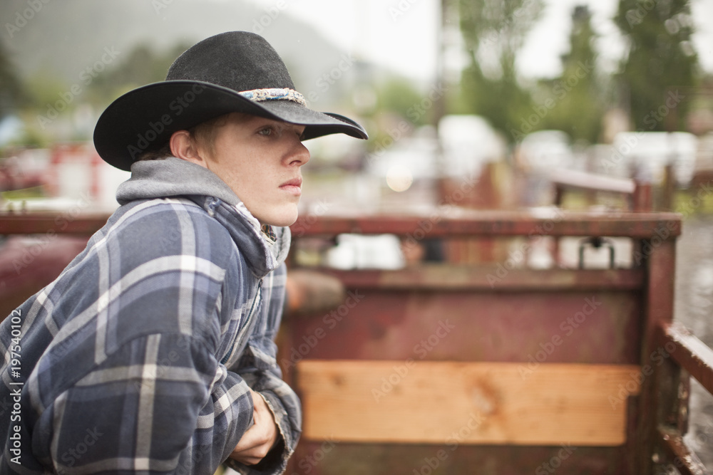 Foto Stock Teen wearing cowboy hat, looking over fence into rodeo arena. |  Adobe Stock