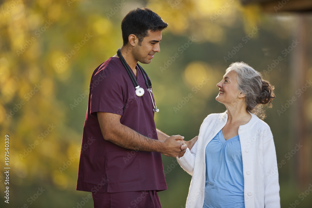 Smiling senior woman and a male doctor having a conversation while ...
