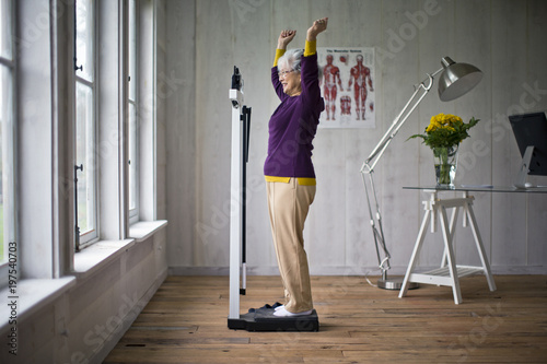 Elderly woman celebrates after stepping on the scales.