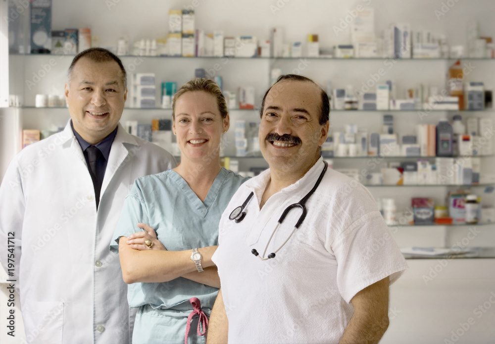 A team of three doctors smile at the camera. A team of three doctors smile at the camera.