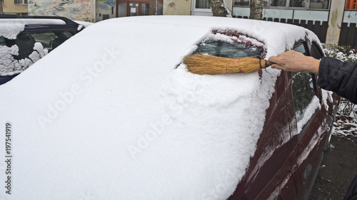 Driver cleaning snow from the rear windshield