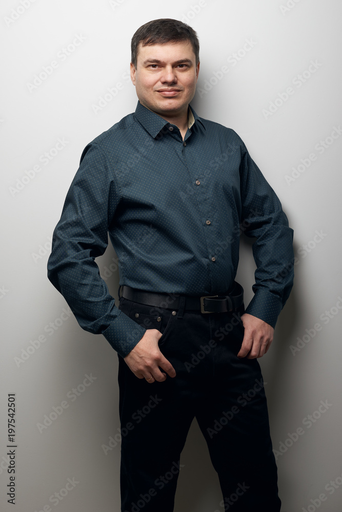 man portrait dressed in dark shirt and black pants over gray background man portrait dressed in dark shirt and black pants over gray background