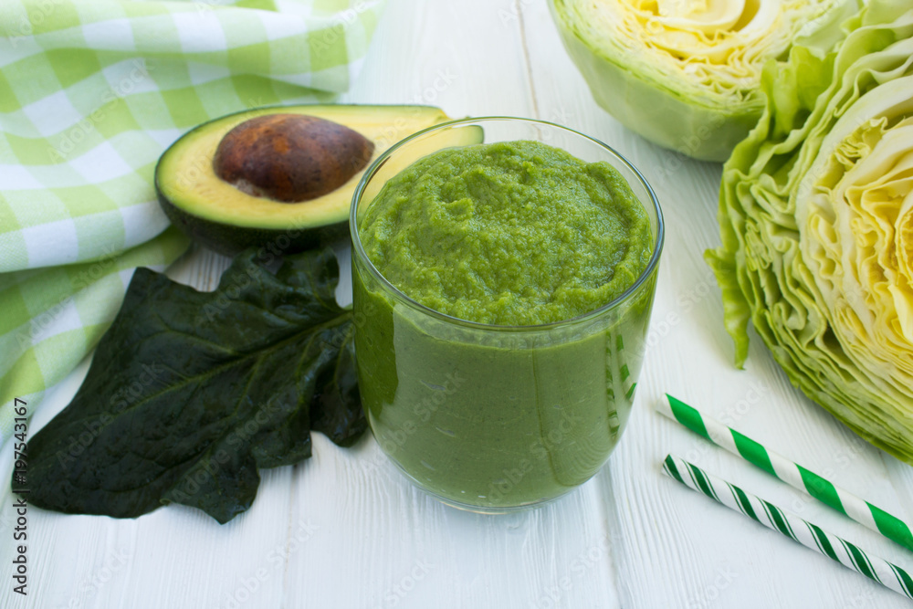 Vegetarian green smoothie with avocado,spihach and cabbage on the white wooden background Vegetarian green smoothie with avocado,spihach and cabbage on the white wooden background