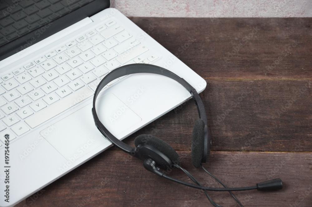 Laptop and earphones on a wooden table. Journalist, online training, remote work, online games Laptop and earphones on a wooden table. Journalist, online training, remote work, online games