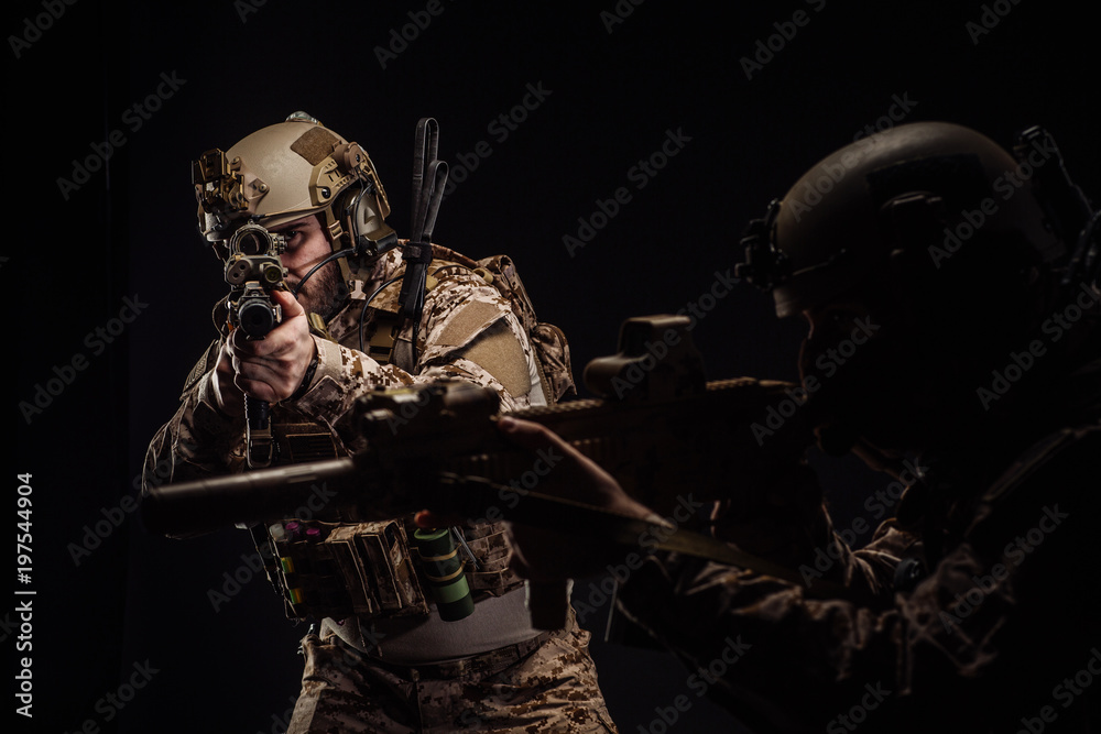 Naklejka premium soldiers or private military contractors holding rifle. Image on a black background. war, army, weapon, technology and people concept