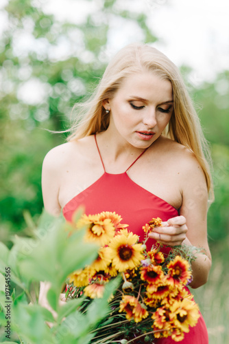 young girl with white hair on nature on a green background with a bouquet of yellow flowers without photoshop photo