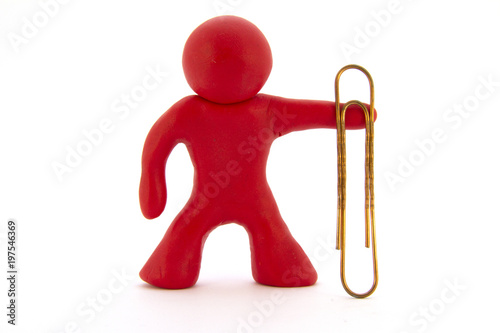 Red plasticine character and big paperclip. Stationery. Isolated over white background photo