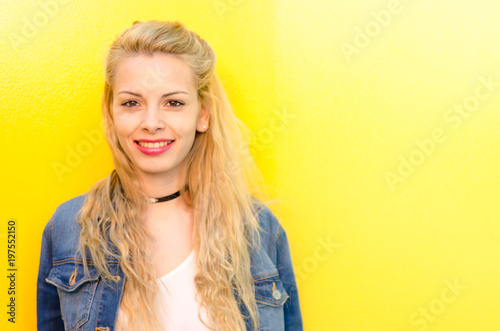 happy young woman smiling at yellow wall © DavidPrado