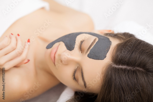 Kobieta w masce na twarzy w salonie piękności spa.