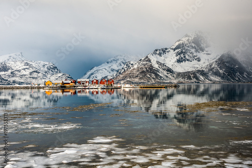 Scenery with reflected cottages and clouds in Lofoten, Norway