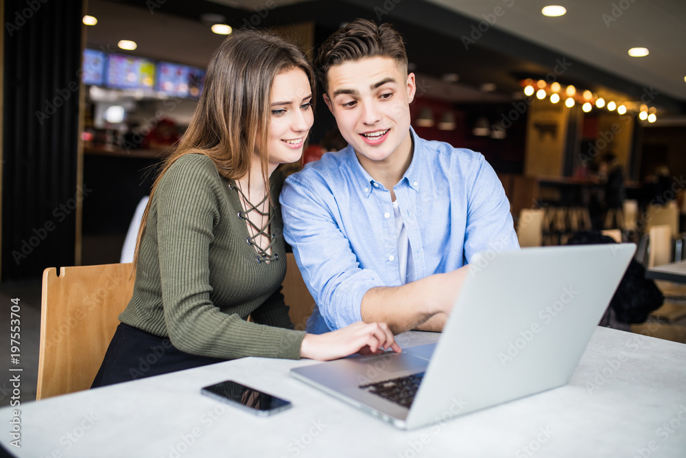 Couple enjoying the wireless internet at cafe. couple use laptop in cafe Couple enjoying the wireless internet at cafe. couple use laptop in cafe