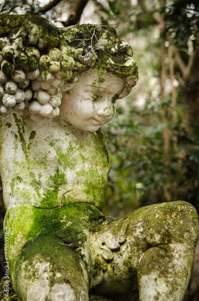 Stone statue of a child in the forest Stone statue of a child in the forest