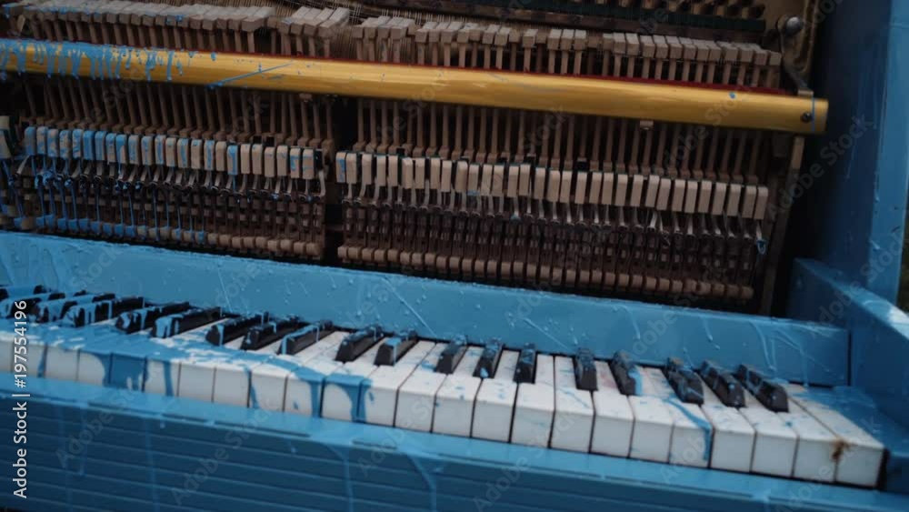 Blue painted old piano. Painted piano, musical style, grunge instrument. Pop and classical music, melody, rhapsody. Art, decoration, design, old piano. Piano in blue paint stain, keyboard. Blue painted old piano. Painted piano, musical style, grunge instrument. Pop and classical music, melody, rhapsody. Art, decoration, design, old piano. Piano in blue paint stain, keyboard.
