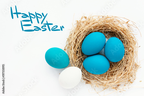 Blue colored Easter eggs in nest on wooden background, selective focus image. Happy Easter card 