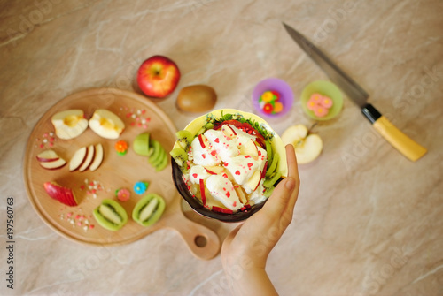 Завтрак из фруктов. Фруктовый десерт с мороженым. Киви и яблоко на кухонной круглой деревянной доске. Ломтики фруктов. Здоровая пища. Полезные сладости. 