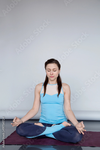 Young woman in sportswear practicing gyan (wisdom, knowledge) mudra with copy space