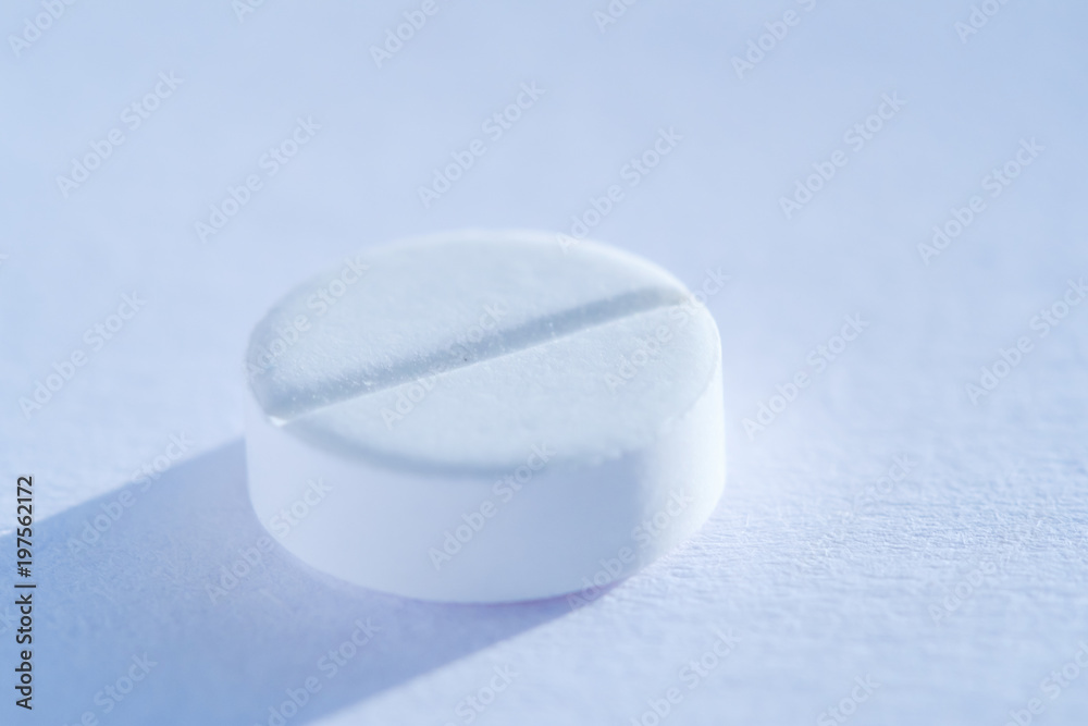 Pill tablet medicine lying isolated on white, extreme close-up macro. Pill tablet medicine lying isolated on white, extreme close-up macro.