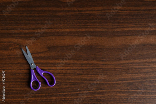 Children scissors on wooden desk