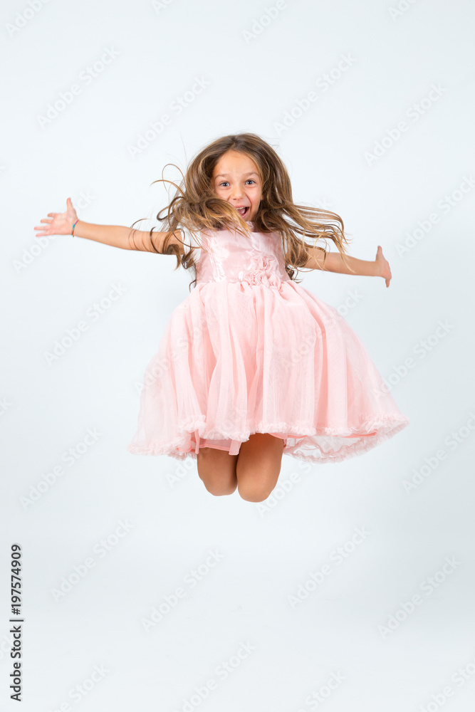 Naklejka premium Bambina castana in abito rosa che salta