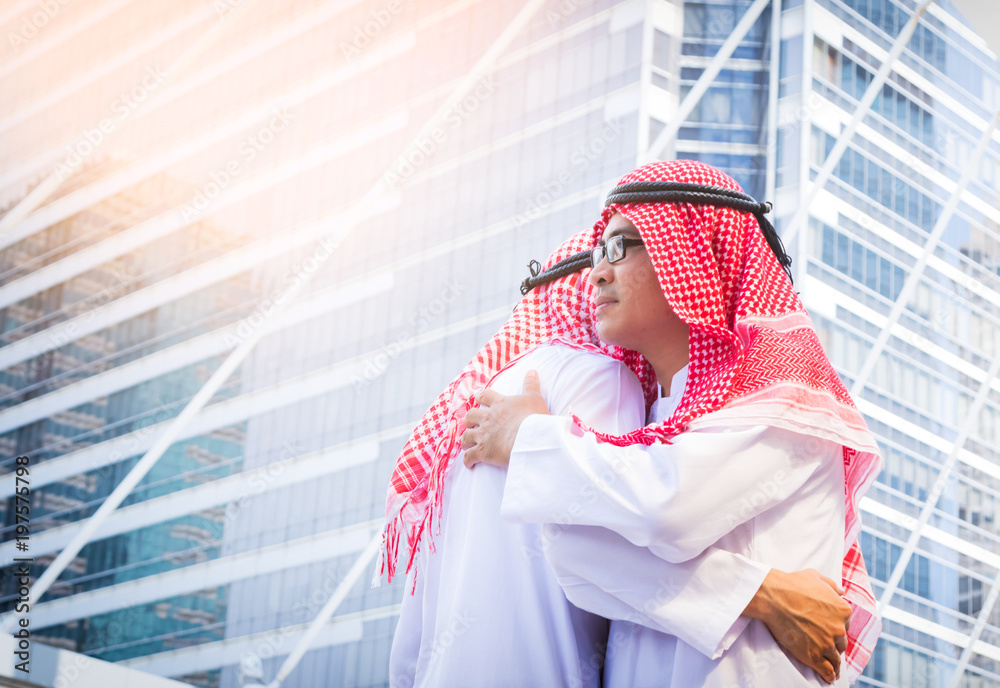 Business success concept. Asian muslim businessman greeting with a hug on city background