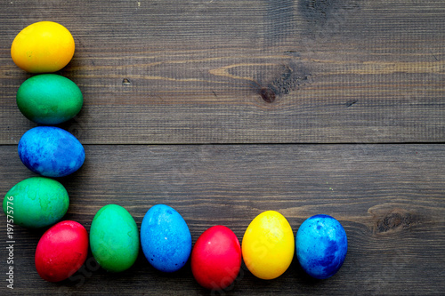 Colorful easter eggs with sweets gingerbread on wooden background top view mockup