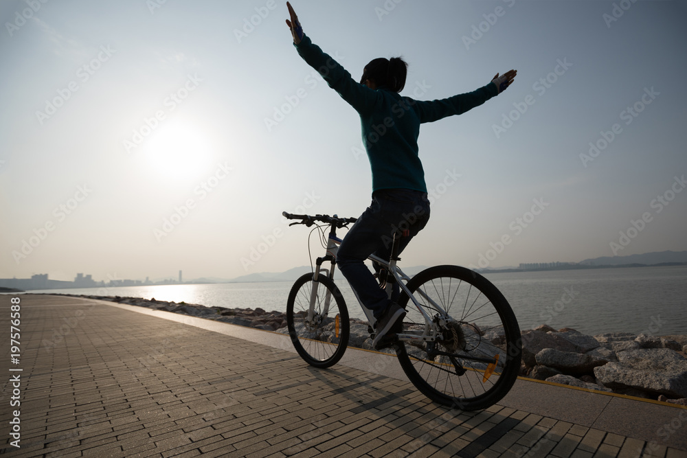 Fototapeta premium silhouette cyclist riding bike in the sunrise coast road