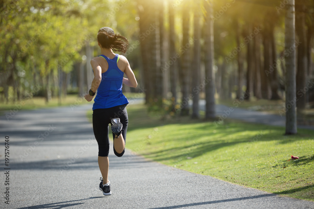 sporty young fitness woman running at tropical park sporty young fitness woman running at tropical park