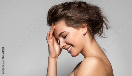 Cuadro en lienzo Beautiful woman with perfect skin and bare shoulders in profile on a gray backgr